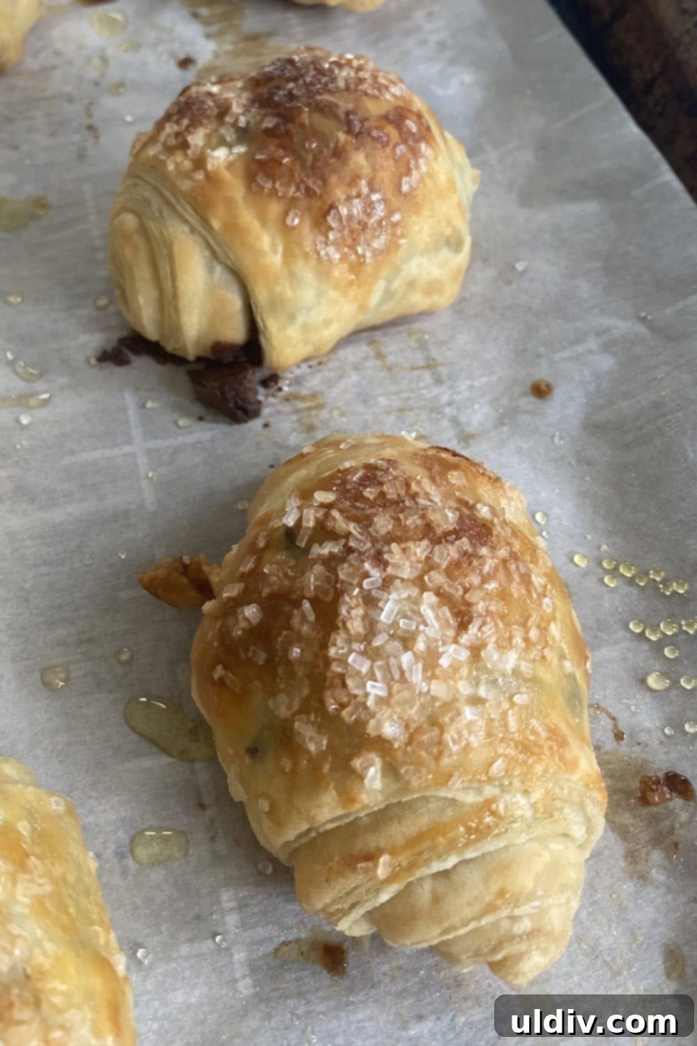 Flaky Chocolate Puff Bites 5 two perfectly baked chocolate puff pastry rolls, showcasing their golden crust and sparkling sugar