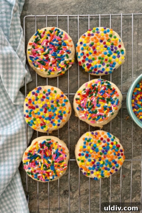 Perfect Drop Sugar Cookies No Rolling No Cutting 2 Six vibrant sugar cookies, adorned with rainbow sprinkles, neatly arranged on a cooling rack, showcasing their perfect thickness and soft texture. An inviting sight for any celebration.