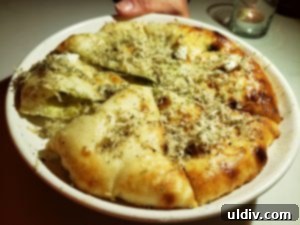 A close-up shot of freshly baked, fluffy garlic naan from ROOH.