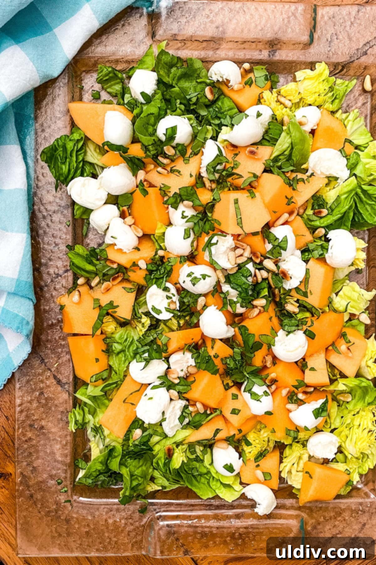 Sweet Melon & Savory Mozzarella Salad with Pine Nuts 4 Sliced cantaloupe, fresh mozzarella balls, and pine nuts arranged on a rustic surface, ready for the summer salad.