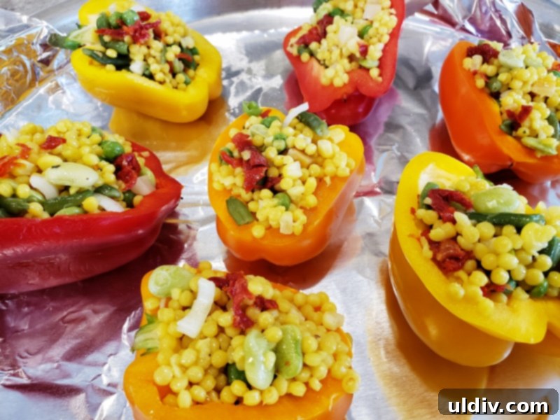 Pantry Perfect Vegan Stuffed Peppers 5 Bell pepper halves filled with couscous mixture and arranged on a baking pan