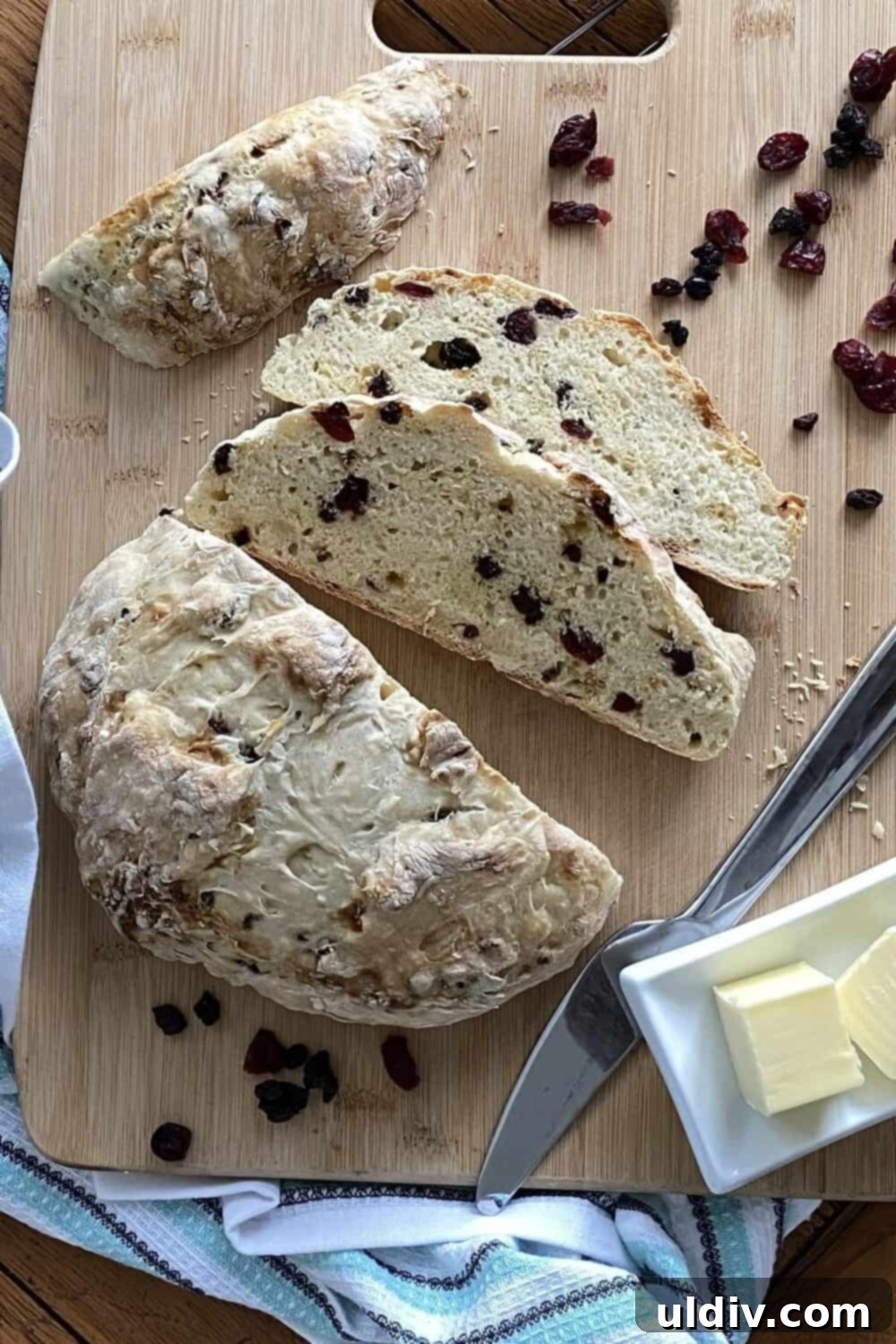 Ruby Berry Irish Soda Bread 6 A loaf of soda bread and 2 slices on a cutting board.