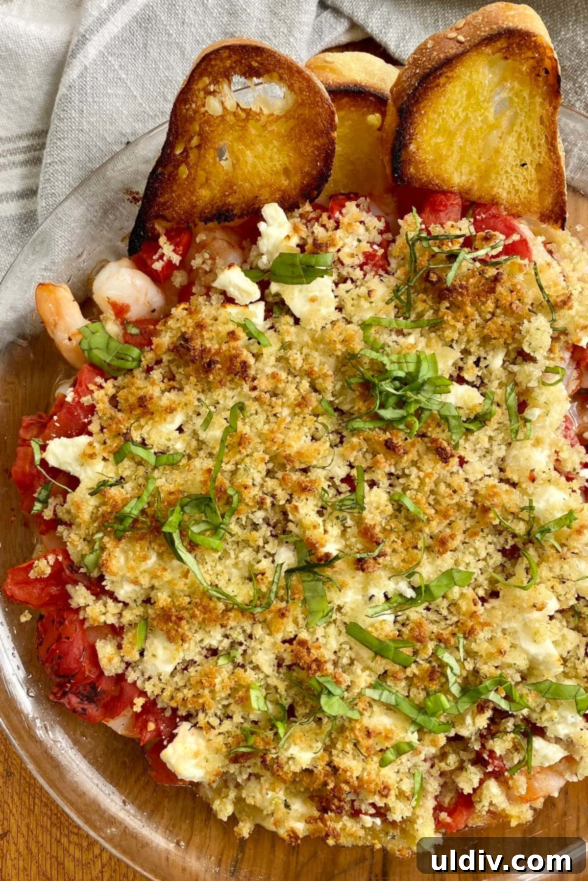 Mediterranean Feta Shrimp Bake 2 A beautifully presented baked shrimp with feta and tomatoes served with crostinis, highlighting the crispy panko topping and vibrant colors.