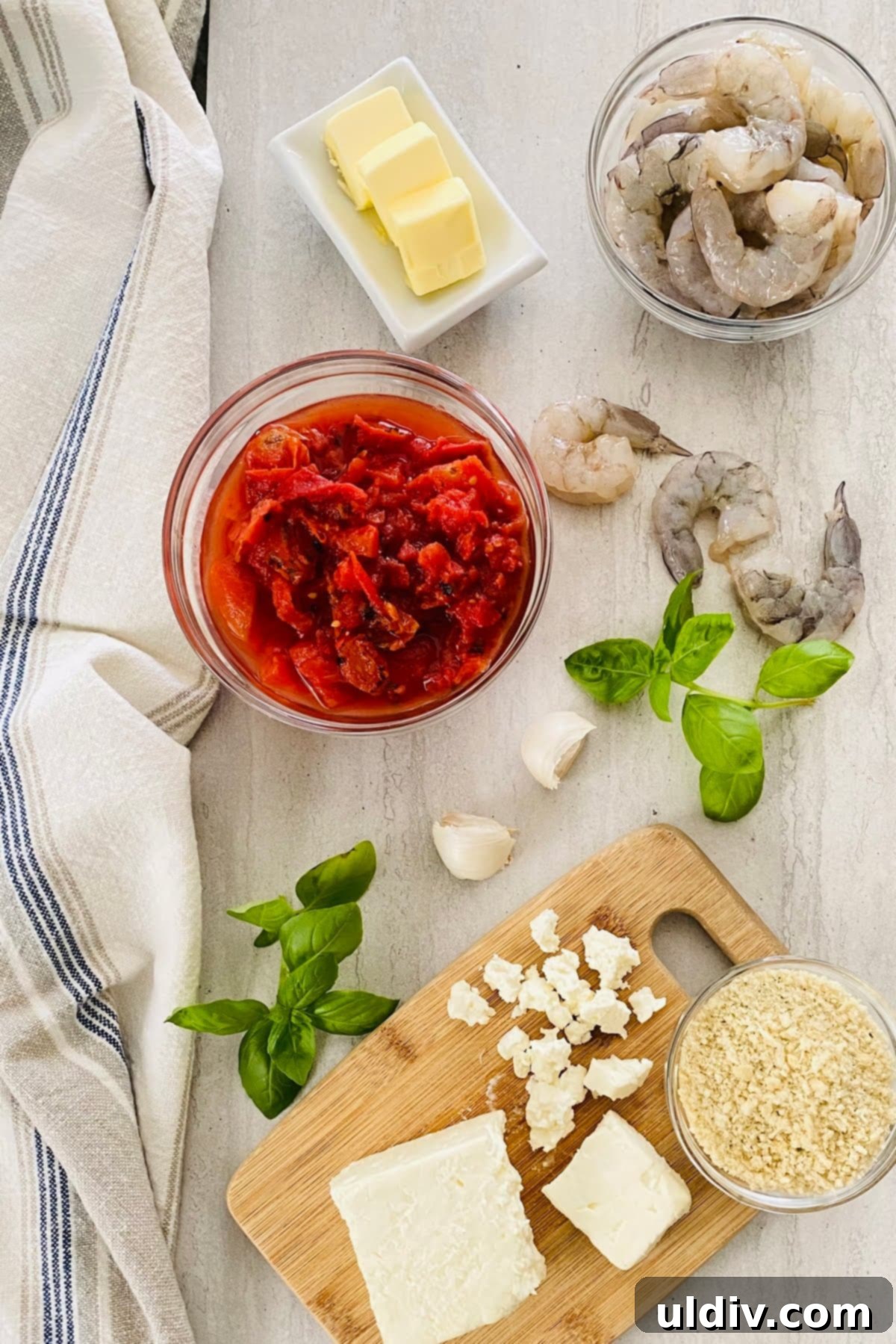 Mediterranean Feta Shrimp Bake 3 Close-up of fresh ingredients: raw shrimp, crumbled feta cheese, canned fire-roasted diced tomatoes, panko breadcrumbs, fresh basil leaves, butter, and garlic, ready for cooking.