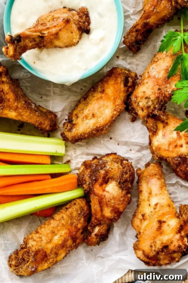 Ultimate Oven-Baked Wings 6 appetizer platter featuring crispy baked chicken wings alongside a bowl of blue cheese dip, and fresh celery and carrot sticks