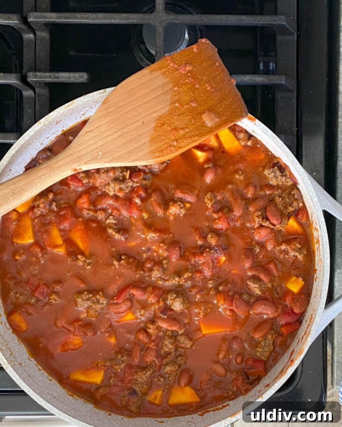 Chili simmering on the stove in a large pot.