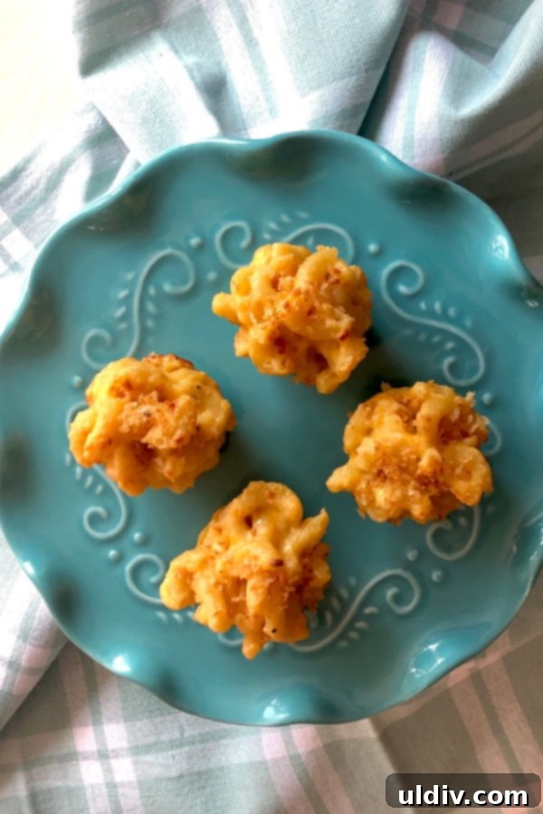 Four mini mac and cheese bites on a teal plate