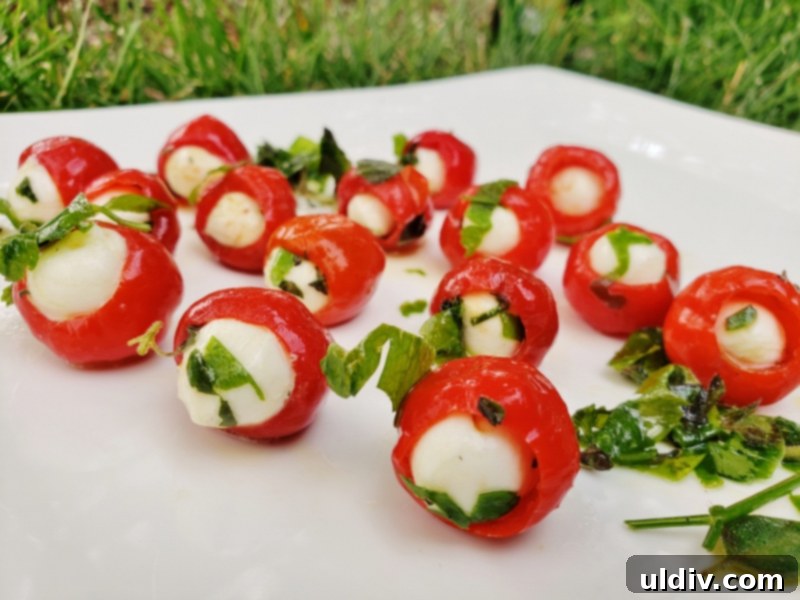 Herb-Packed Peppadew & Mozzarella 4th of July Appetizer 5 Stuffed Peppadew peppers on a white plate, some drizzled with balsamic vinegar