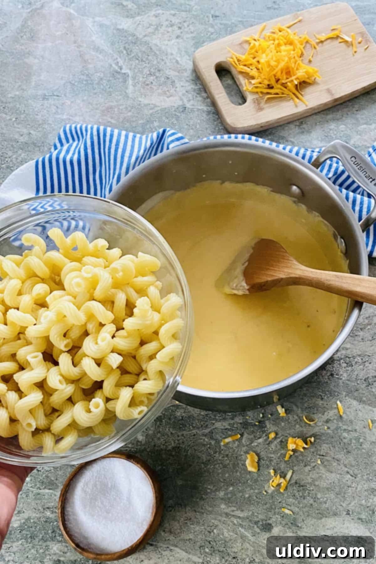 Effortless Golden Mac and Cheese 4 Close-up of a pot containing creamy cheese sauce mixed with cooked fusilli pasta, ready to be served.