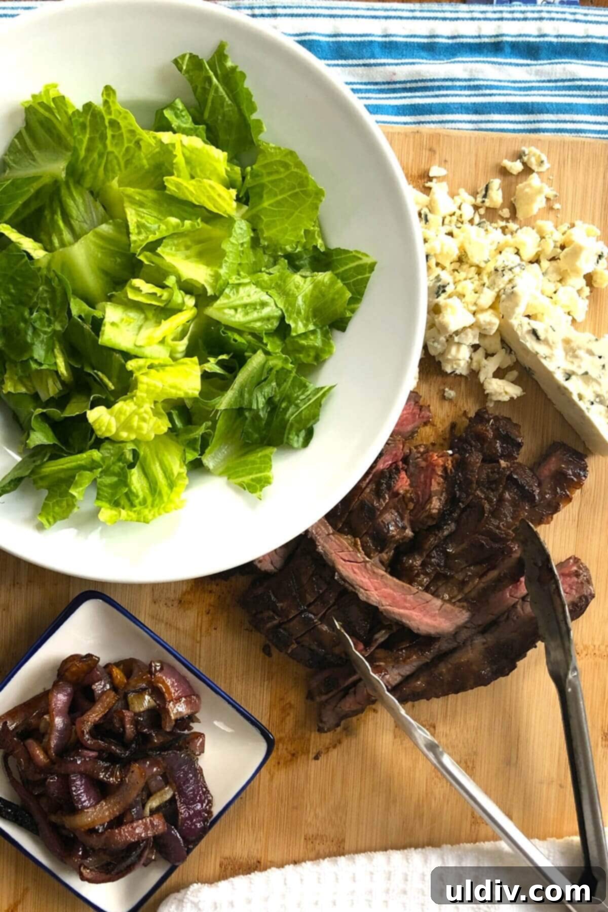 Balsamic Herb Grilled Steak Salad with Crumbled Blue Cheese 4 Individual ingredients for balsamic herb steak salad: chopped romaine lettuce, crumbled blue cheese, roasted red onions, and perfectly sliced skirt steak arranged for assembly.