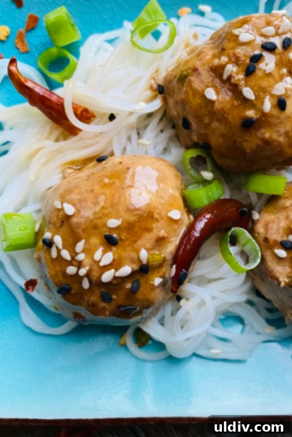 General Tso Glazed Meatballs 2 General Tso's meatballs over rice noodles and with peppers.