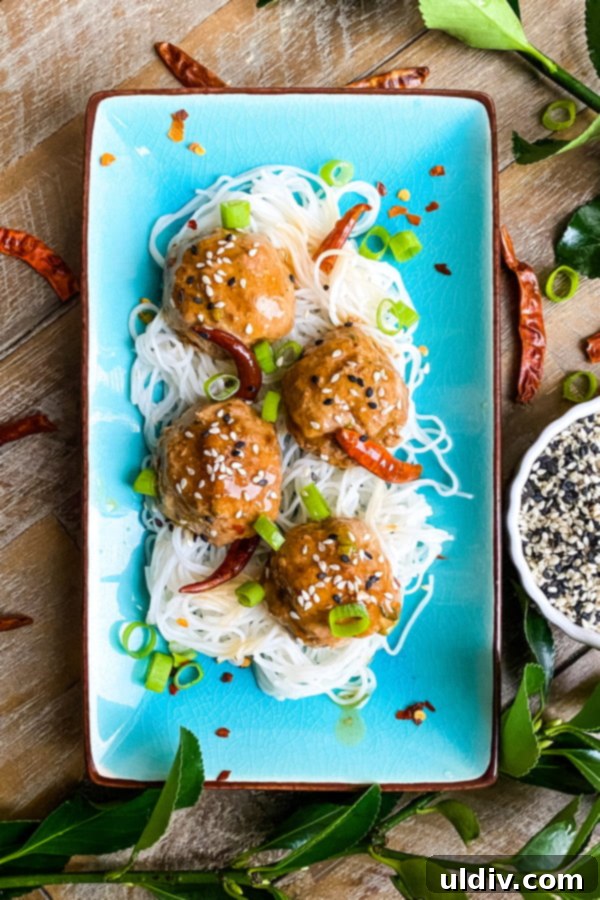General Tso Glazed Meatballs 6 4 spicy General Tso's meatballs on a plate with rice noodles