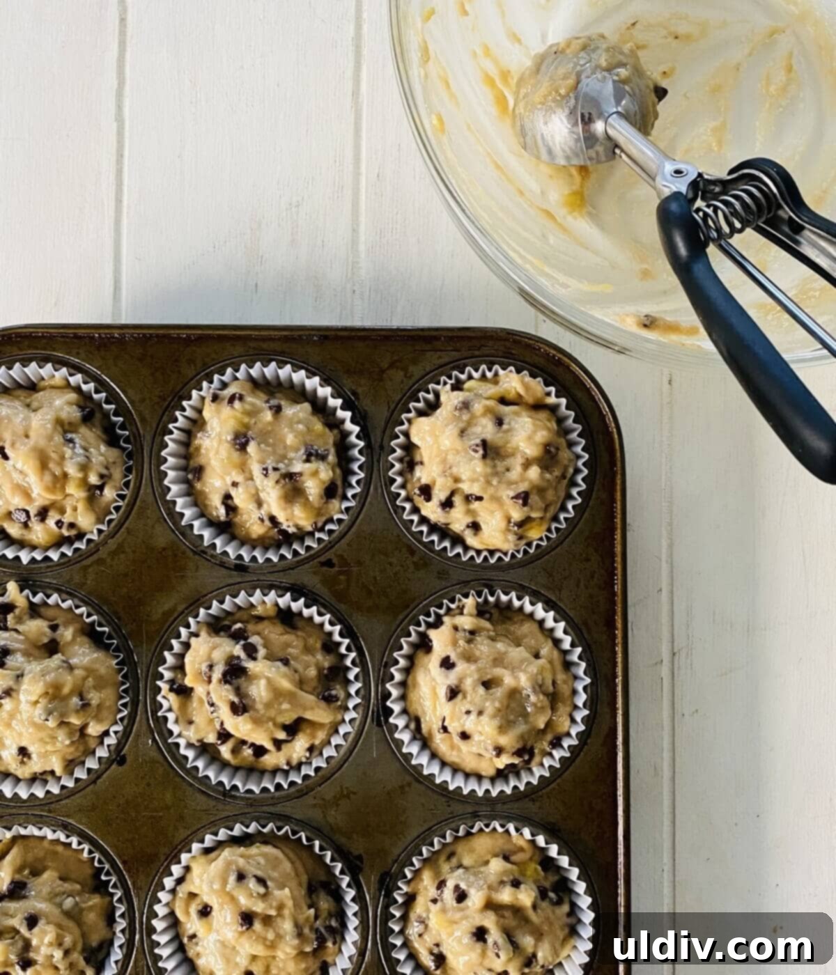 Naturally Sweet Vegan Banana Muffins 12 An empty batter bowl next to a full muffin pan with unbaked dairy-free banana muffin batter, ready for the oven.