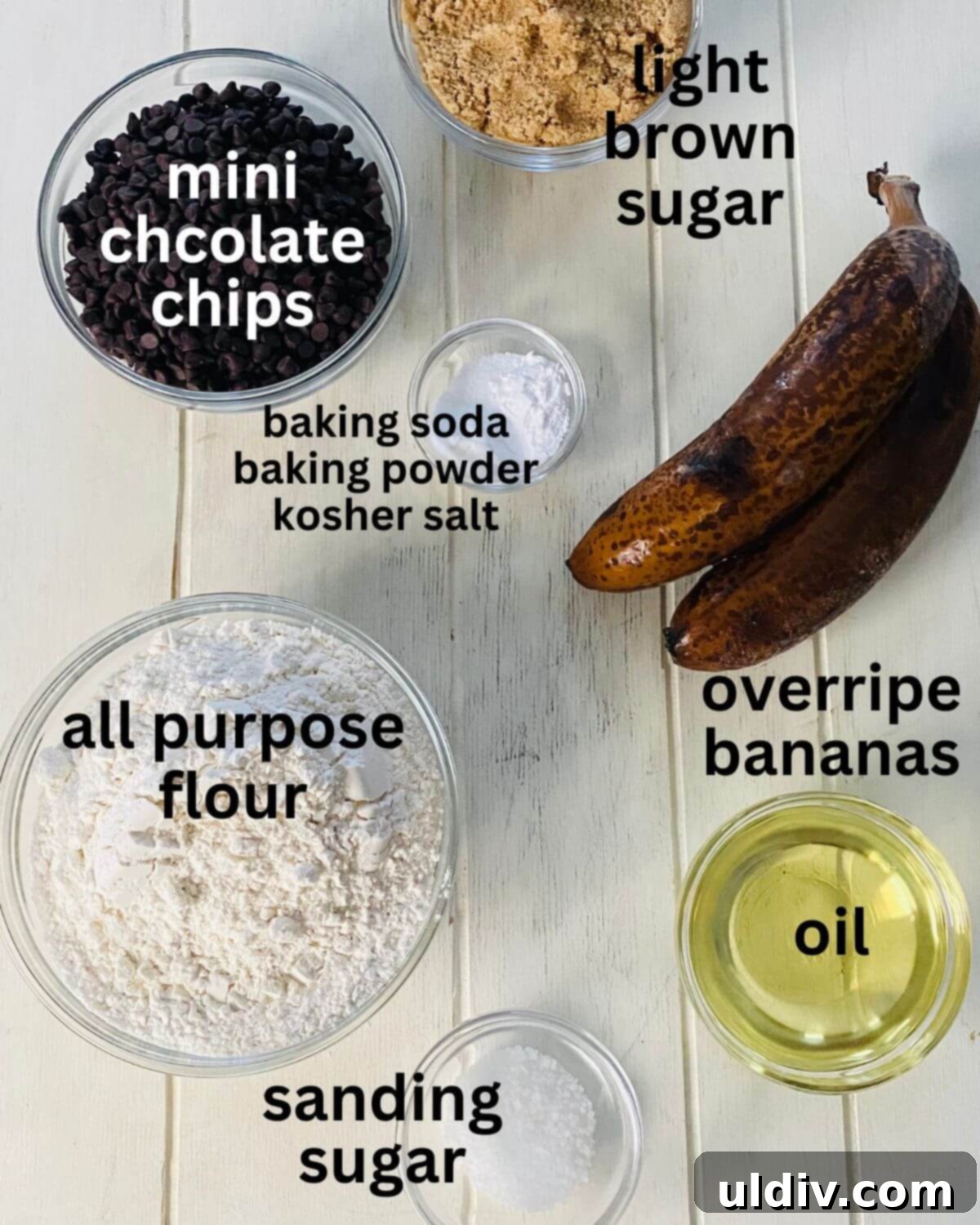 Irresistible Vegan Banana Muffins 4 A selection of ingredients for dairy-free banana muffins including ripe bananas, flour, brown sugar, mini chocolate chips, oil, baking soda, baking powder, and salt.