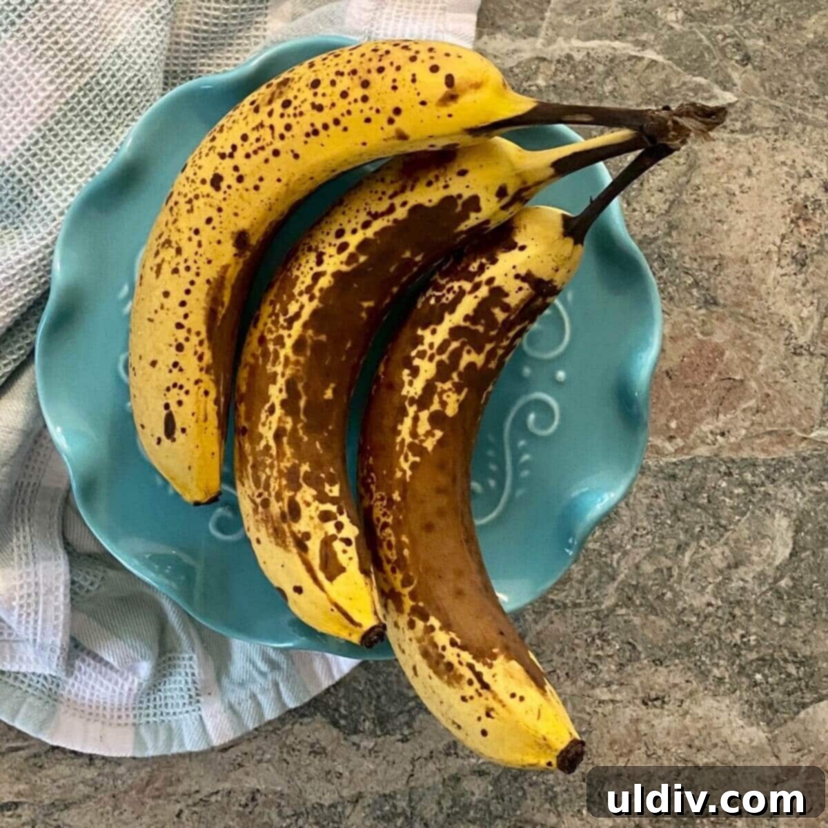 Naturally Sweet Vegan Banana Muffins 5 A cluster of extremely ripe bananas with dark brown and black spots, perfect for baking muffins.