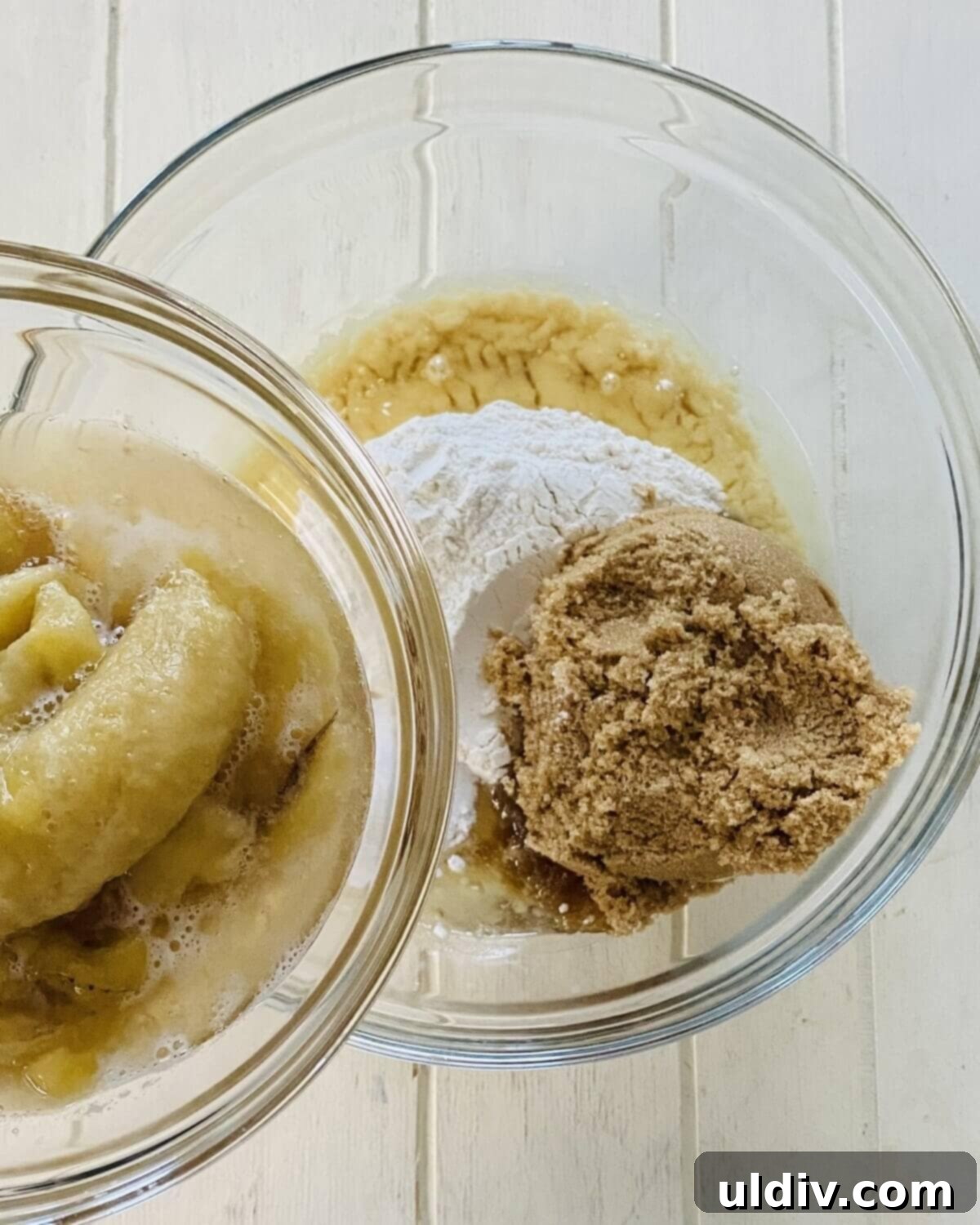 Irresistible Vegan Banana Muffins 7 Adding mashed ripe bananas to a bowl with dry ingredients, baking soda, baking powder, and kosher salt.