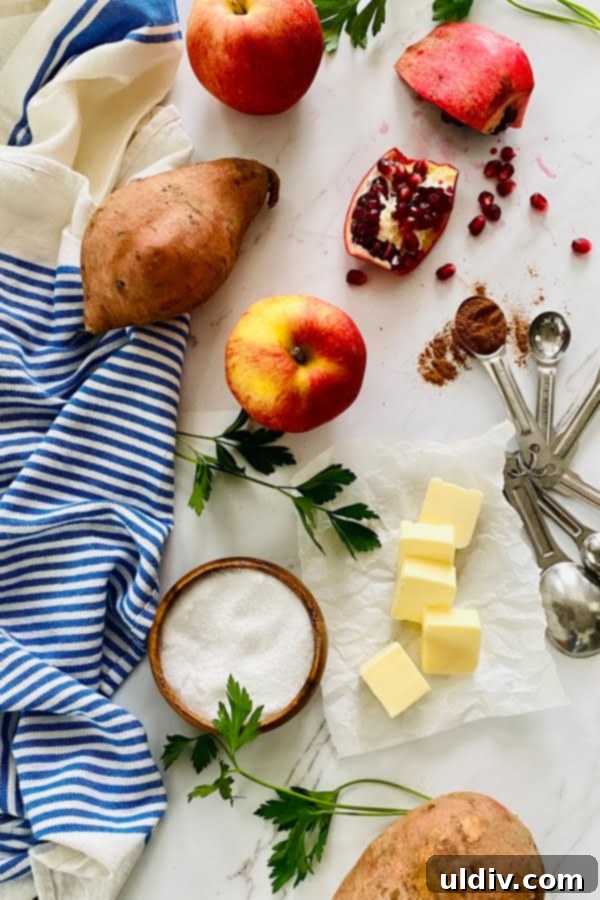 Loaded Sweet Potatoes: Apple, Bacon & Pomegranate 3 A vibrant display of fresh ingredients including sweet potatoes, apples, bacon, and pomegranate arils, ready for a delicious Thanksgiving side dish.