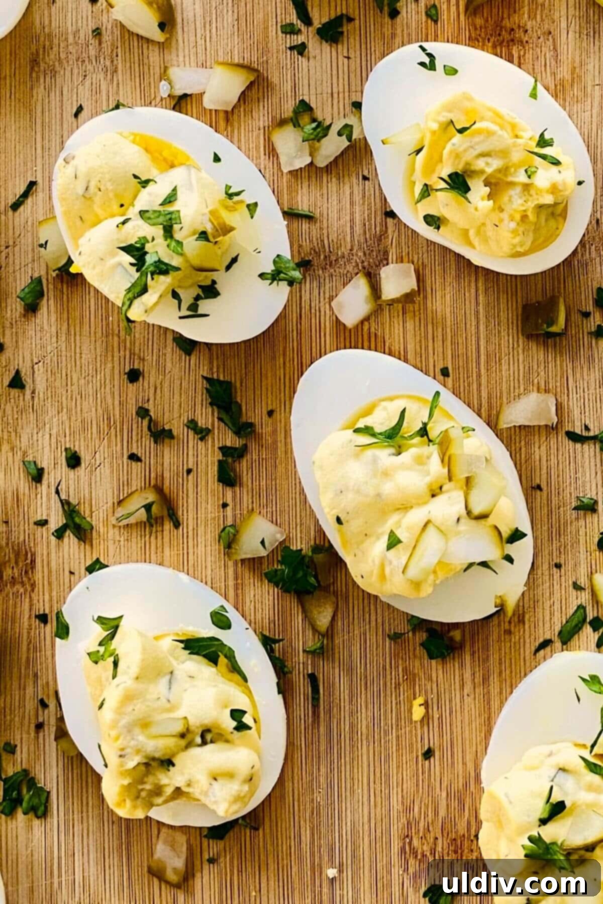 Zingy Dill Pickle Deviled Eggs 2 4 deviled eggs with dill pickles on a cutting board.