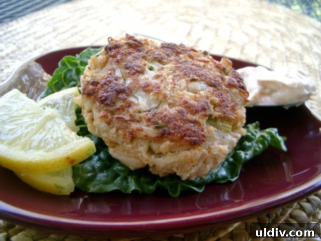 A jumbo lump crab cake with a lemon wedge and fresh herbs.