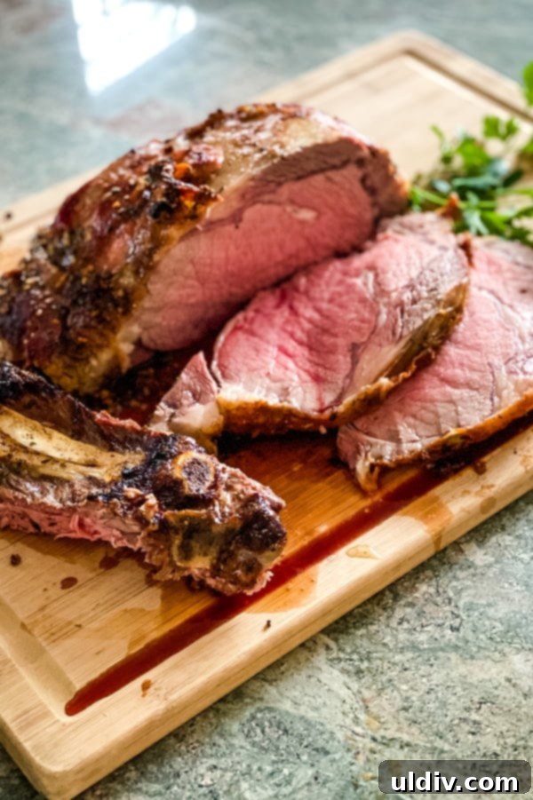 Melt-in-Your-Mouth Slow-Roasted Prime Rib 7 Two generous slices of medium-rare slow roasted prime rib rest on a cutting board, illustrating the perfect internal doneness and juicy texture.