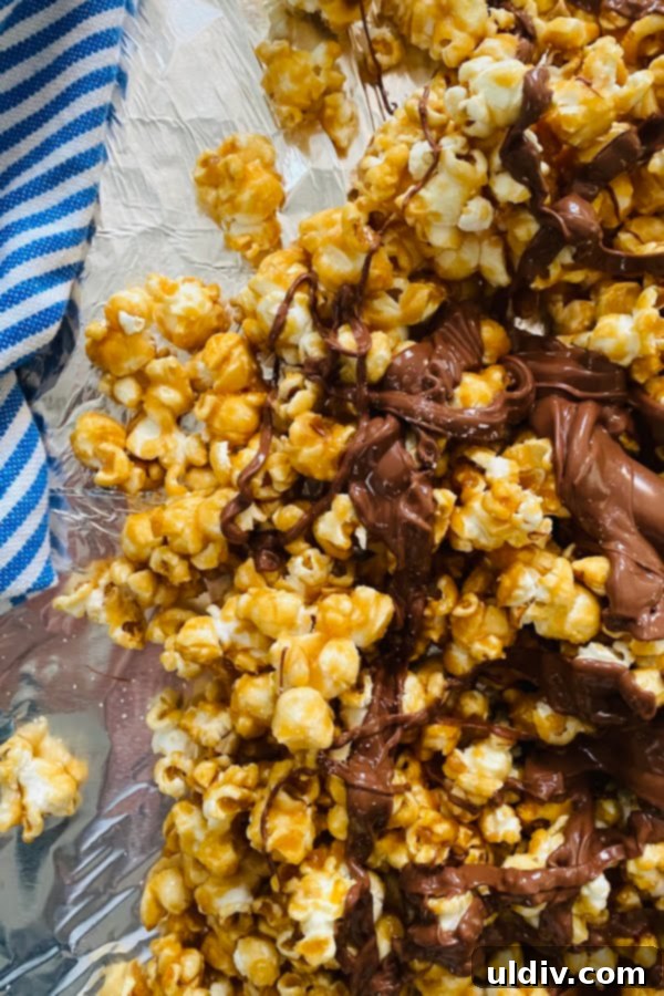 Irresistible Homemade Salted Caramel Popcorn 6 Close-up of golden brown salted caramel popcorn artfully arranged in a bowl, with delicate drizzles of melted dark chocolate creating an appealing pattern. The texture is crunchy and inviting.