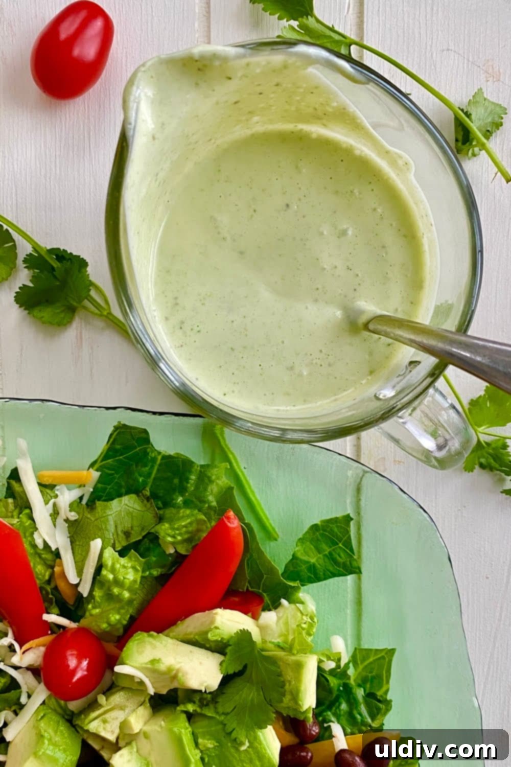 Velvet Cilantro Lime Dressing 2 glass pitcher with creamy cilantro lime salad dressing, garnished with fresh cilantro and lime slices