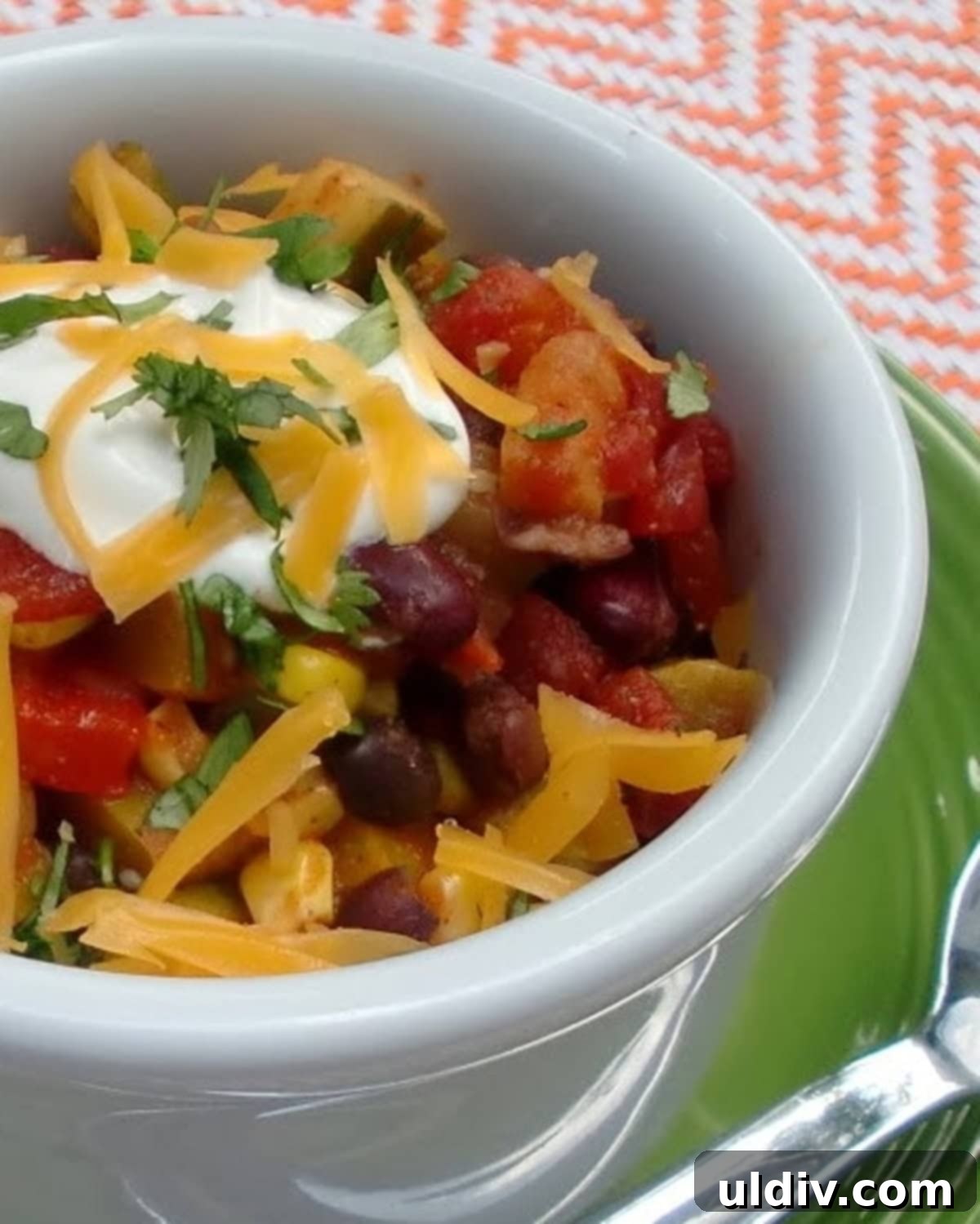 A close up shot of a hearty vegetable chili with visible beans and spices.