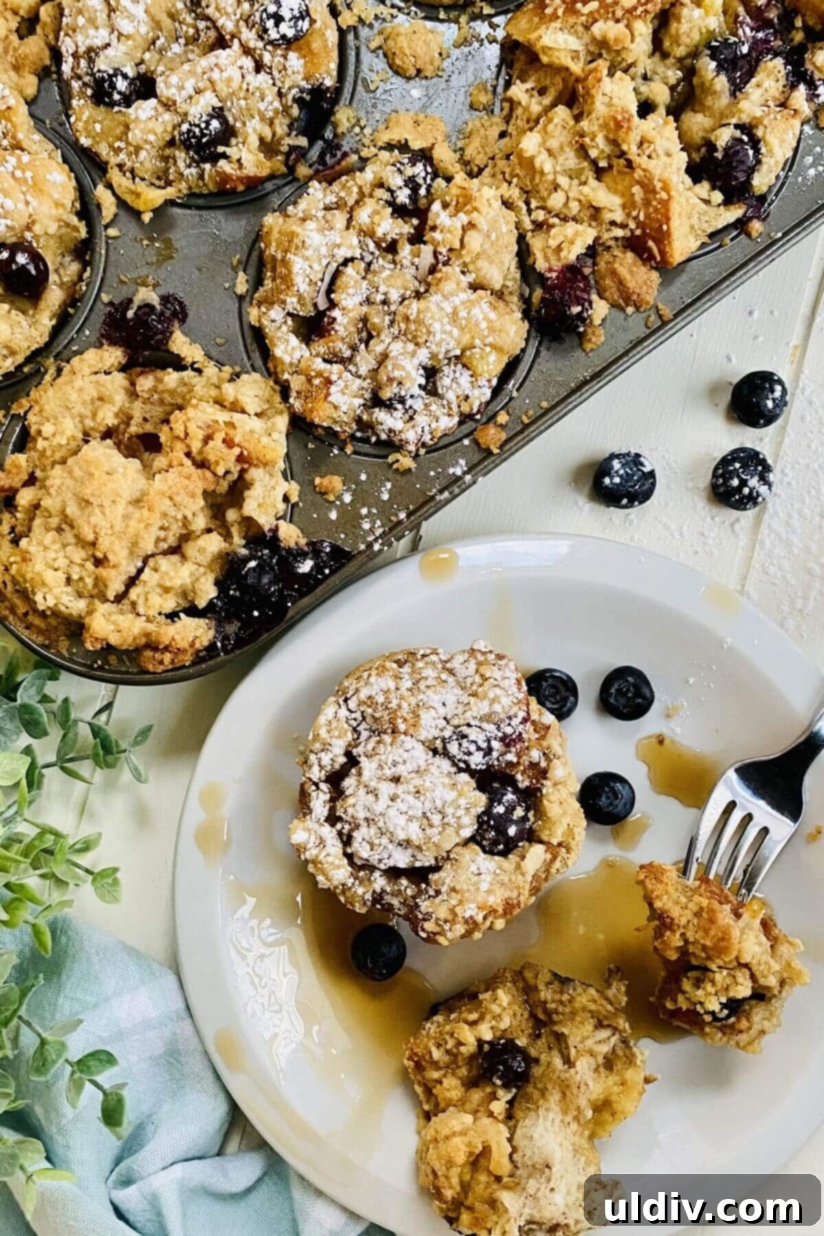 Blueberry Coconut Cinnamon French Toast Muffins 3 A collection of freshly baked French toast muffins, artfully arranged on a cooling rack, with a small pitcher of maple syrup ready for drizzling.