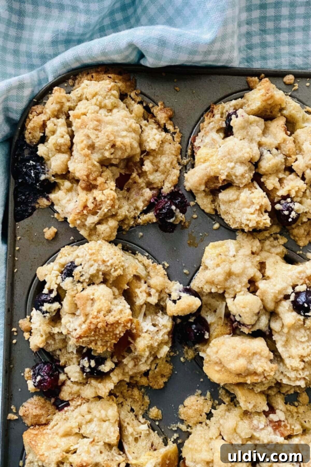 Cinnamon Coconut French Toast Muffins Bursting with Blueberries 5 A batch of golden-brown French toast muffins, baked to perfection in a nonstick muffin tin, showcasing their delightful streusel tops.