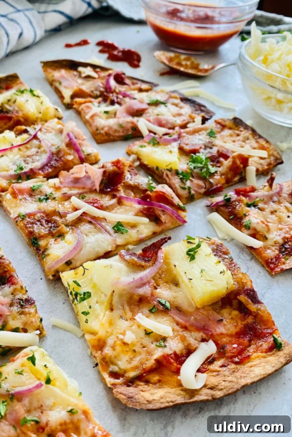 Hawaiian Pizza Tortillas 6 Several slices of thin-crust tortilla pizza, showing the crispy base and the delicious toppings of ham, bacon, and pineapple.