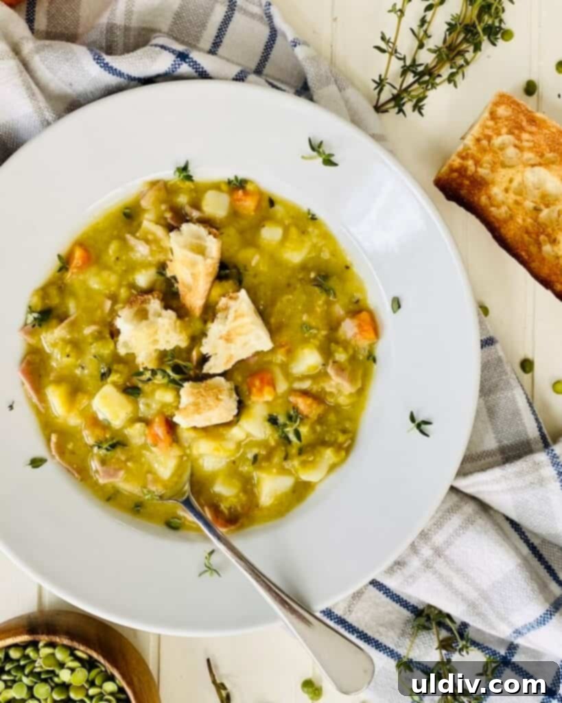 Robust Ham & Potato Split Pea Soup with Crispy Croutons 5 A large, inviting bowl of thick split pea soup, generously topped with golden croutons, with a spoon ready for tasting.