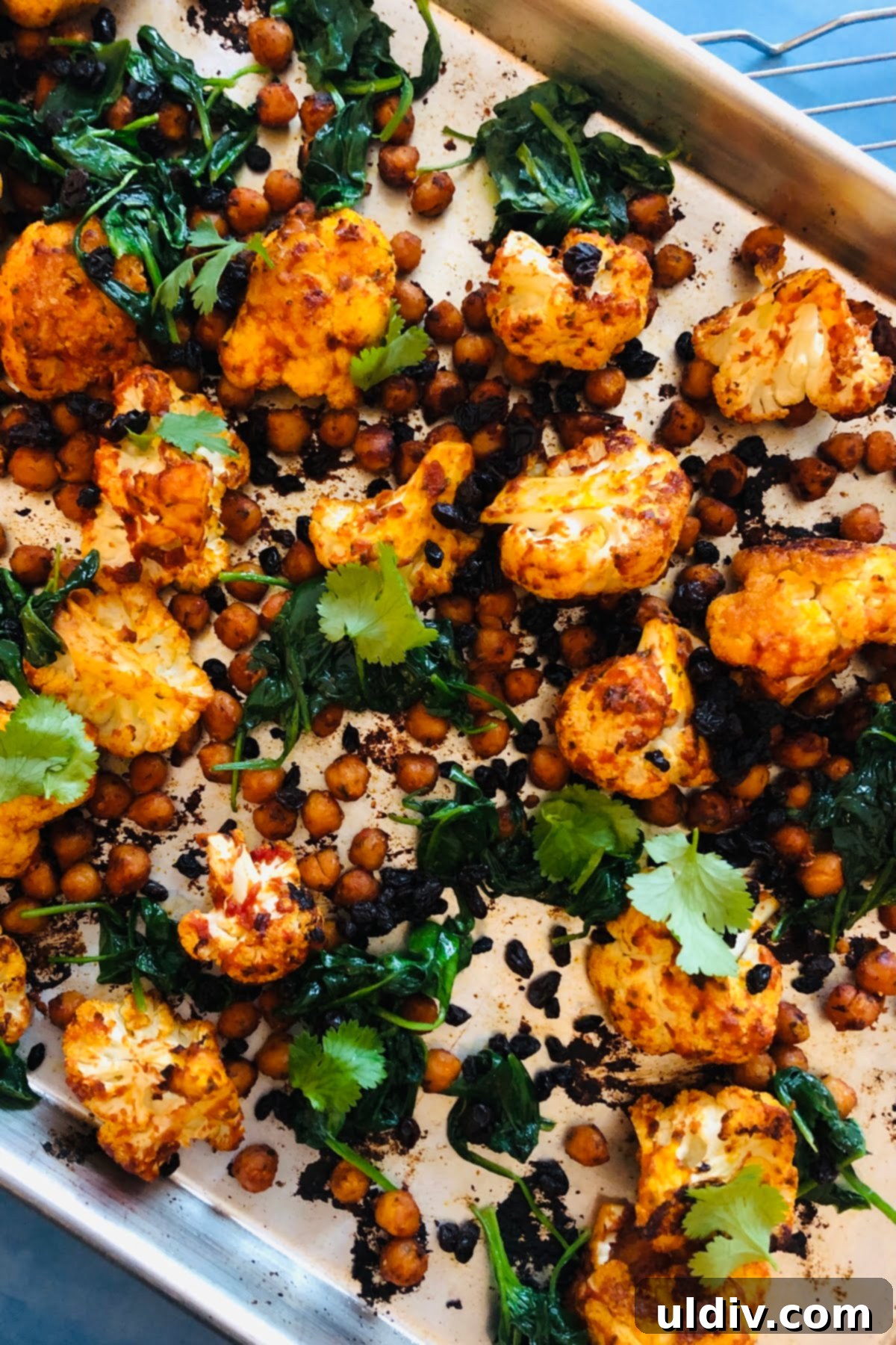 Harissa Fire-Roasted Cauliflower & Chickpea Medley 2 sheet pan with roasted cauliflower, chickpeas and spinach with harissa