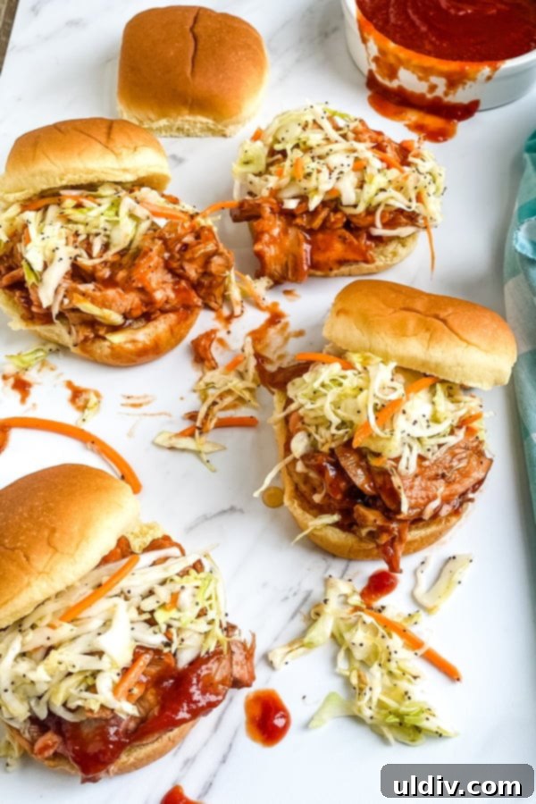 Smoky BBQ Pork Sliders with Zesty Slaw 2 A platter of barbecue pork sliders with cole slaw, ready to be served at a gathering or for a quick family meal.
