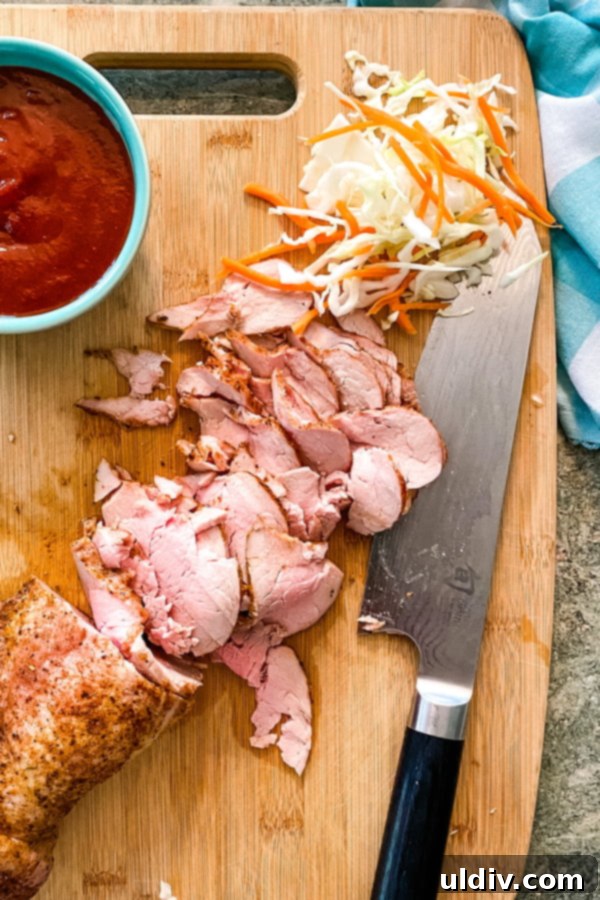 Smoky BBQ Pork Sliders with Zesty Slaw 3 Sliced pork tenderloin and homemade barbecue sauce for sliders on a cutting board, showcasing the fresh ingredients.
