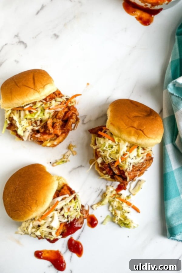 BBQ Pork Tenderloin Minis with Zesty Coleslaw 5 A casual display of small sandwiches, featuring barbecue pork and coleslaw, on slider buns, ready to be enjoyed.