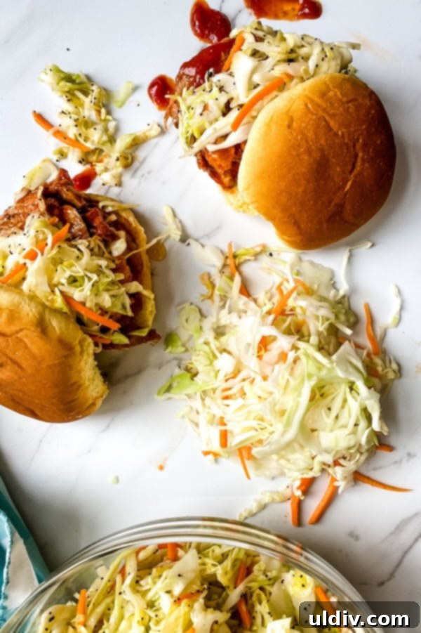 BBQ Pork Tenderloin Minis with Zesty Coleslaw 6 Two enticing Barbecue Pork Tenderloin Sliders paired with a generous serving of fresh, tangy coleslaw, perfect for a balanced meal.