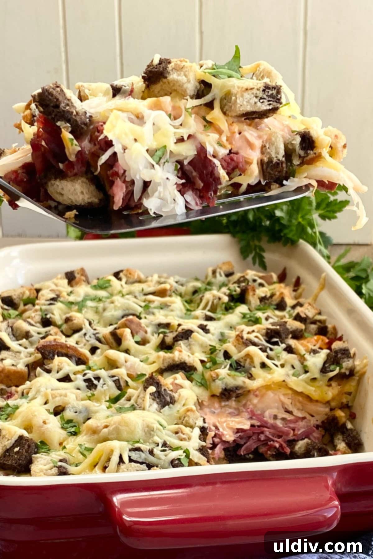 Irresistible Reuben Casserole 2 A perfectly portioned slice of golden-brown Reuben casserole, showcasing its distinct layers of rye bread, corned beef, sauerkraut, and melted Swiss cheese.