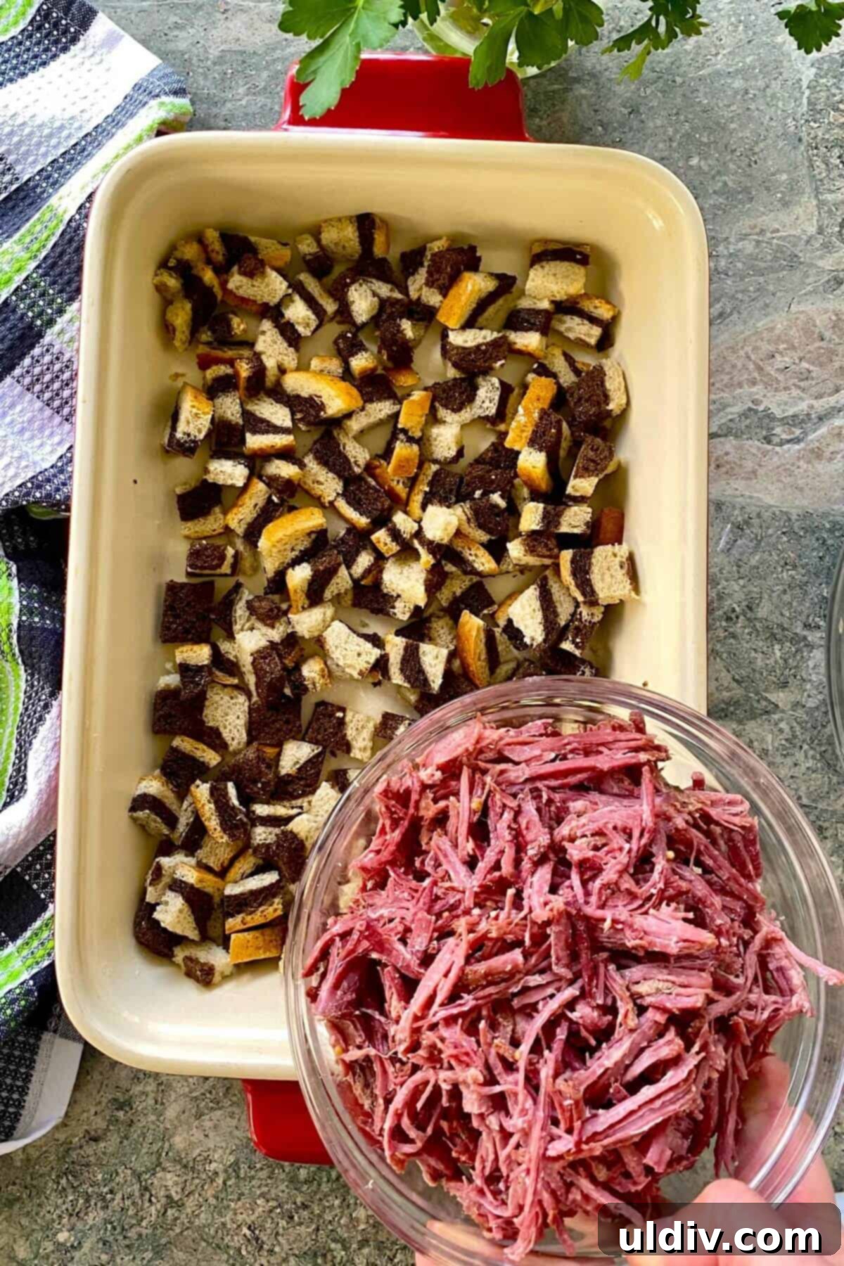 Irresistible Reuben Casserole 5 Adding shredded corned beef as a layer in the Reuben casserole, spread evenly over the initial layer of rye bread cubes.