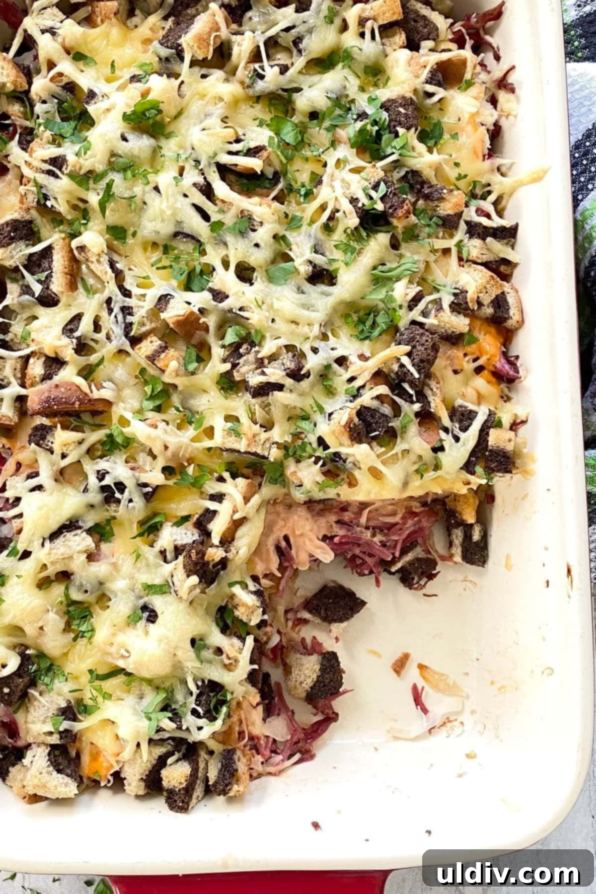 Irresistible Reuben Casserole 9 A perfectly baked, layered Reuben casserole with one slice already removed, highlighting the golden crust and internal layers.