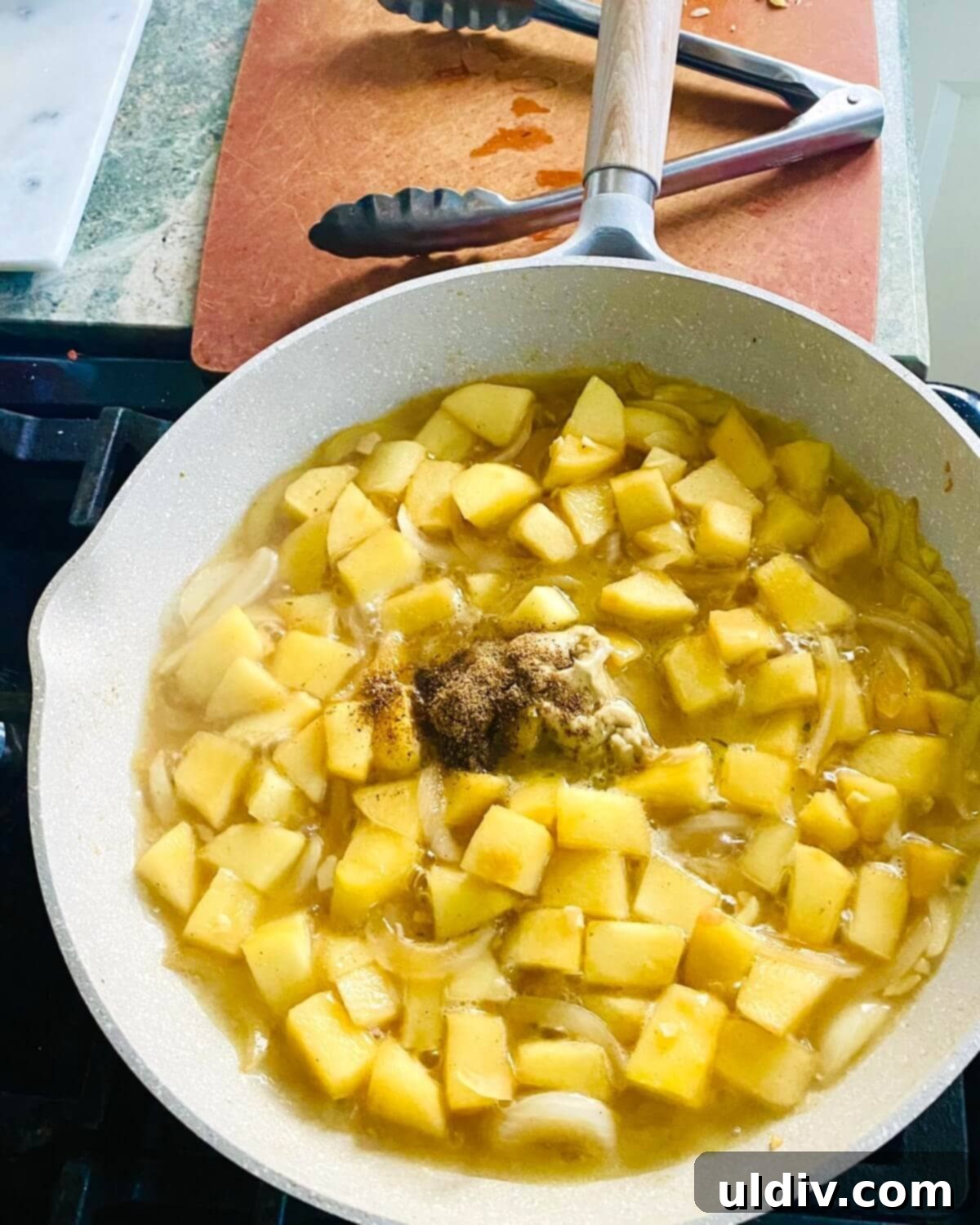 A pan filled with chicken stock, white wine, honey, Dijon mustard, and Garam Masala, simmering to create a rich pan sauce.