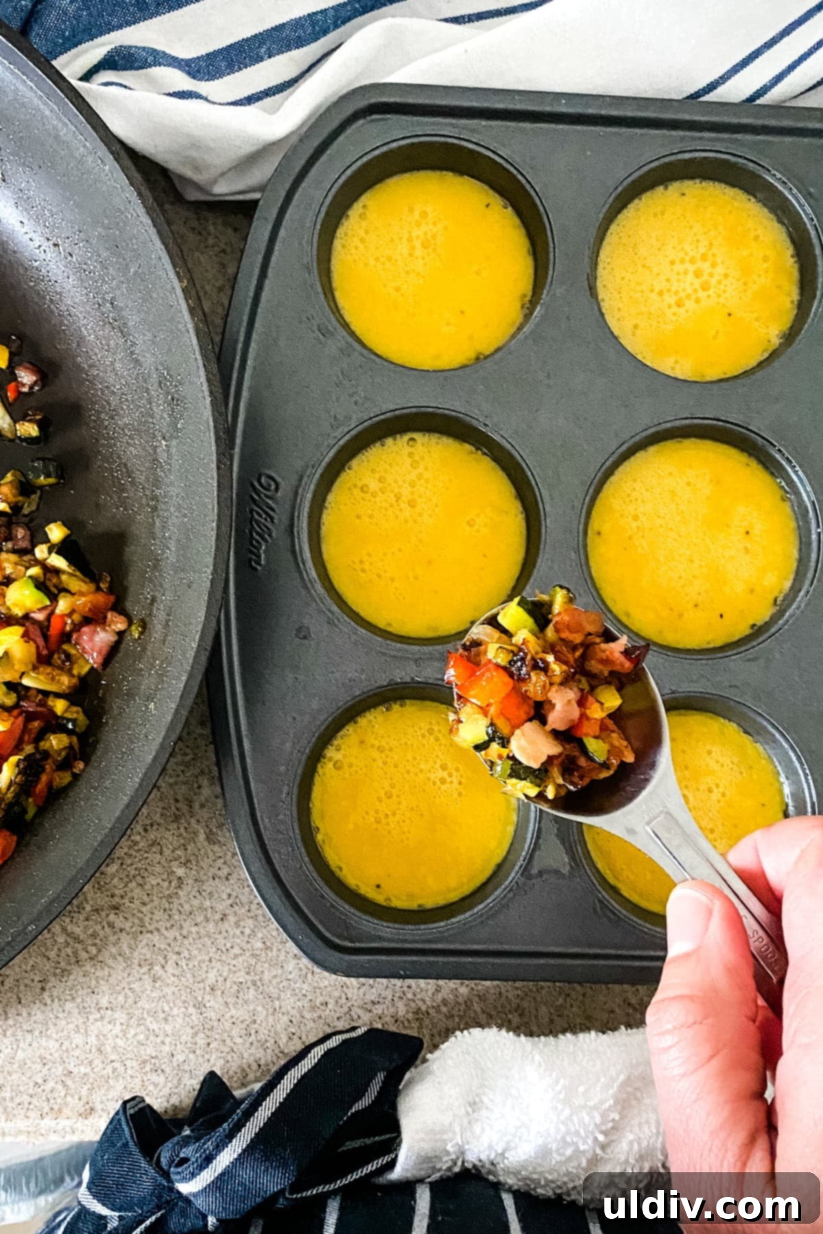 Keto and Paleo Egg Muffins 3 A bowl of whisked eggs with finely chopped, sautéed vegetables being added, ready for the muffin tin.