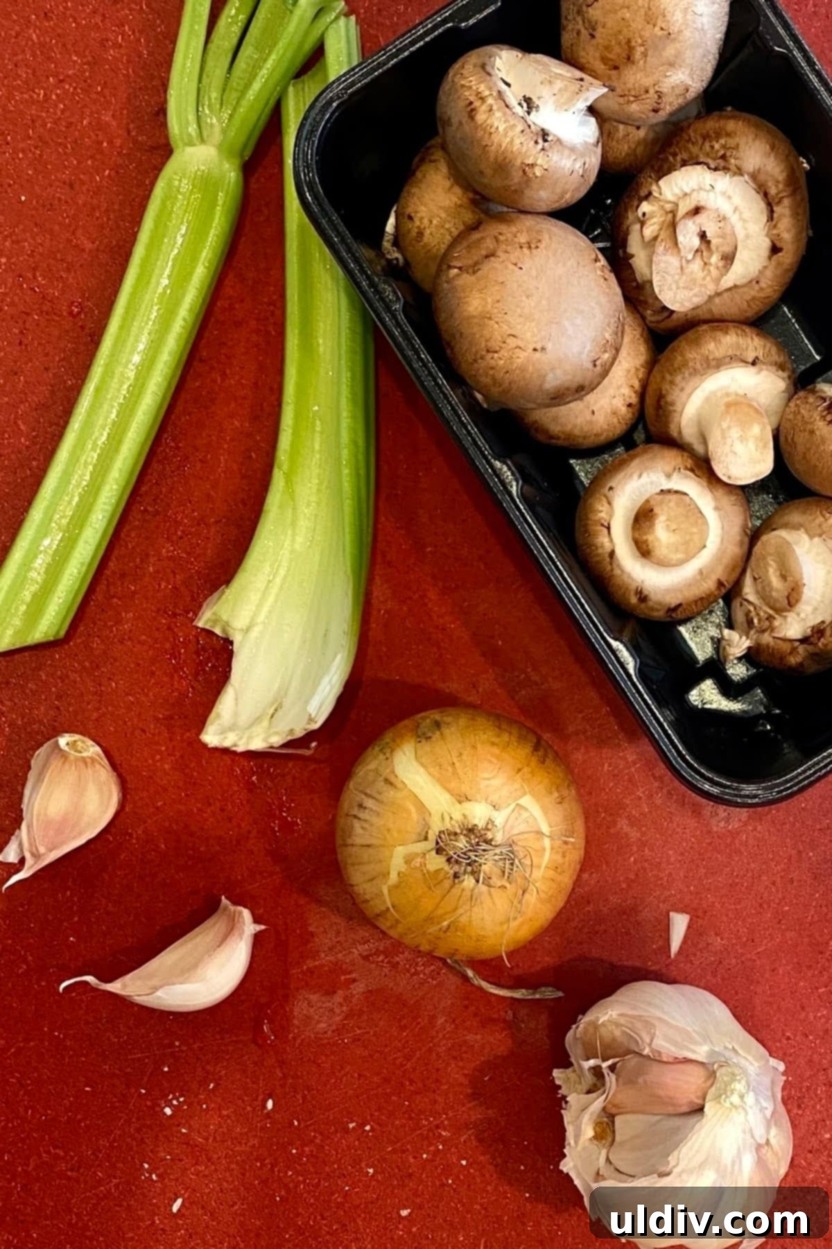 Hearty Turkey Meatloaf with Sautéed Mushrooms 4 Celery, garlic, onion, and mushrooms on a cutting board.