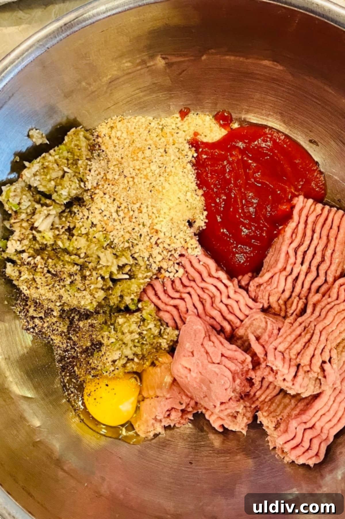 Comforting Turkey Meatloaf with Savory Mushrooms 6 Ground turkey, ketchup, bread crumbs, egg, chopped vegetables, and seasonings are combined in a large metal bowl, ready for mixing to form the meatloaf.