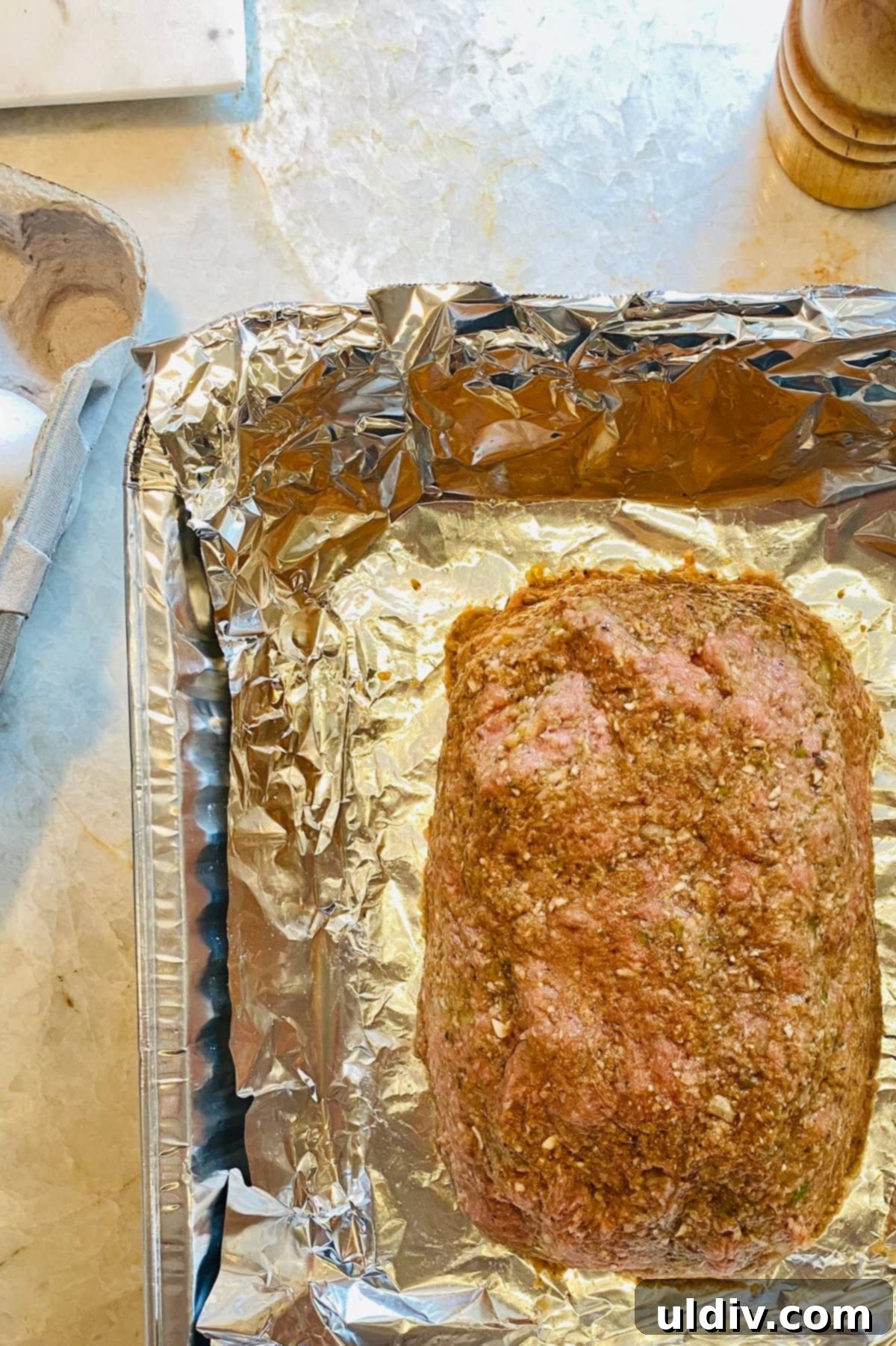 Hearty Turkey Meatloaf with Sautéed Mushrooms 7 An unbaked turkey meatloaf in a foil lined pan.