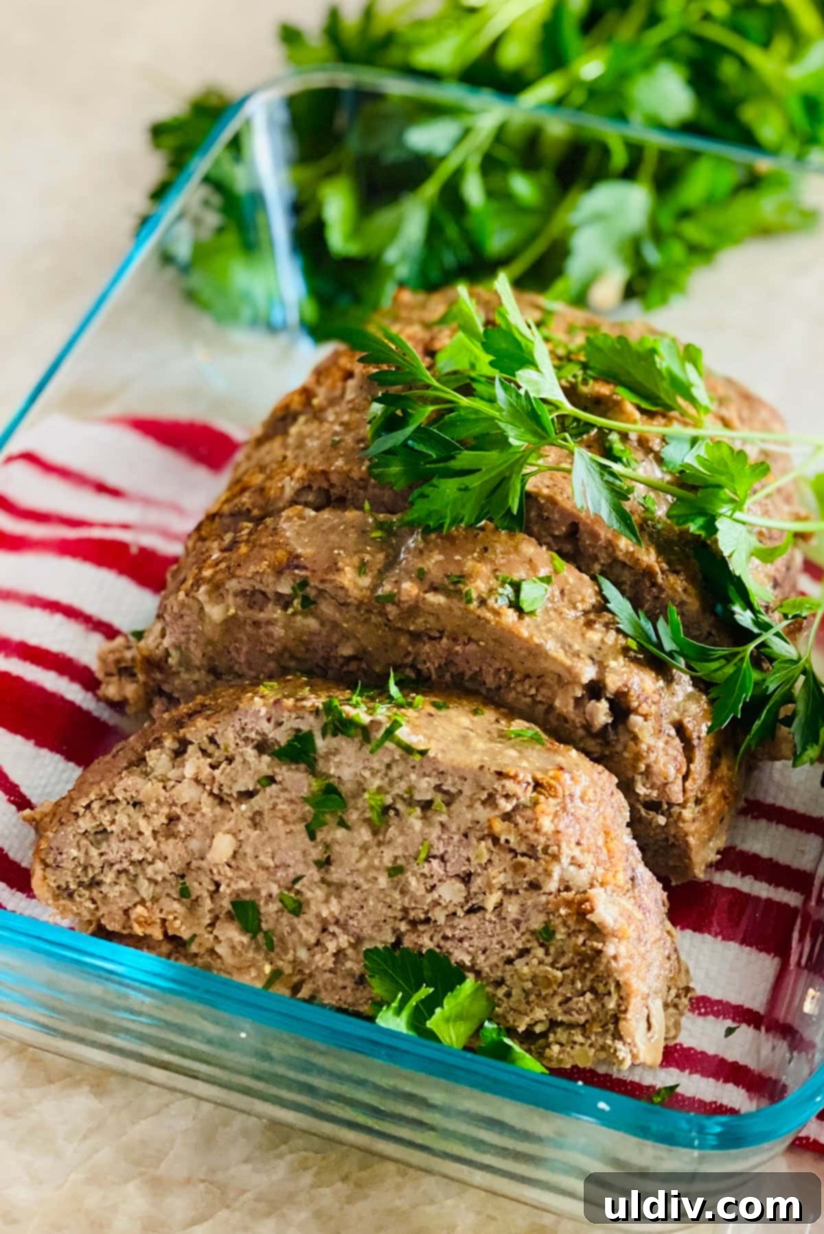 Comforting Turkey Meatloaf with Savory Mushrooms 8 A sliced turkey meatloaf with mushrooms and fresh parsley in a glass baking dish, ready to be enjoyed.