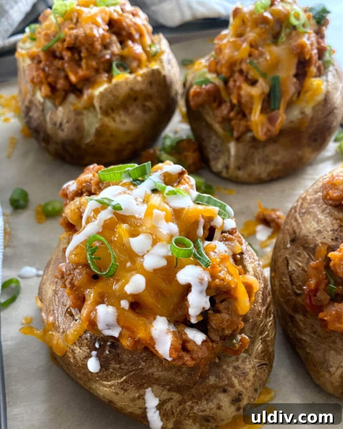 Turkey Sloppy Joe Potato Bake 2 Close-up of a Turkey Sloppy Joe Baked Potato, generously stuffed with a savory turkey filling and topped with melted sharp cheddar cheese, ready to be served.