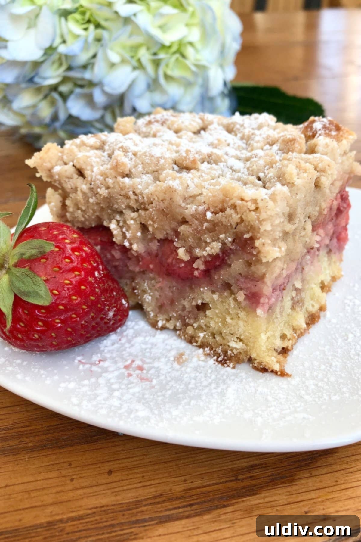 Luscious Strawberry Streusel Cake 2 A perfectly baked slice of fresh strawberry crumb cake, showcasing its golden crumb topping and juicy strawberry layer.