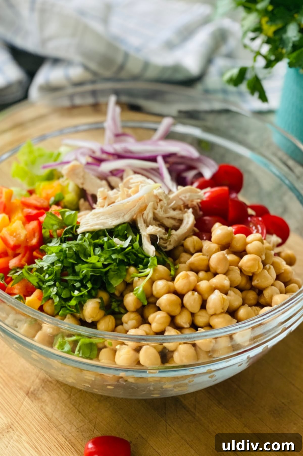 Wholesome Chicken Salad with Roasted Brussels and Crispy Chickpeas 5 chickpeas, tomatoes, chicken, bell peppers, brussels sprout leaves in a large glass bowl