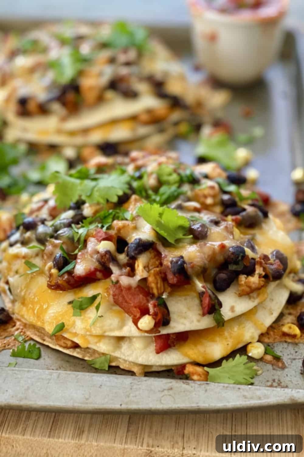 Layered tortilla stacks showing the rich filling of chicken, beans, corn, and cheese before baking.