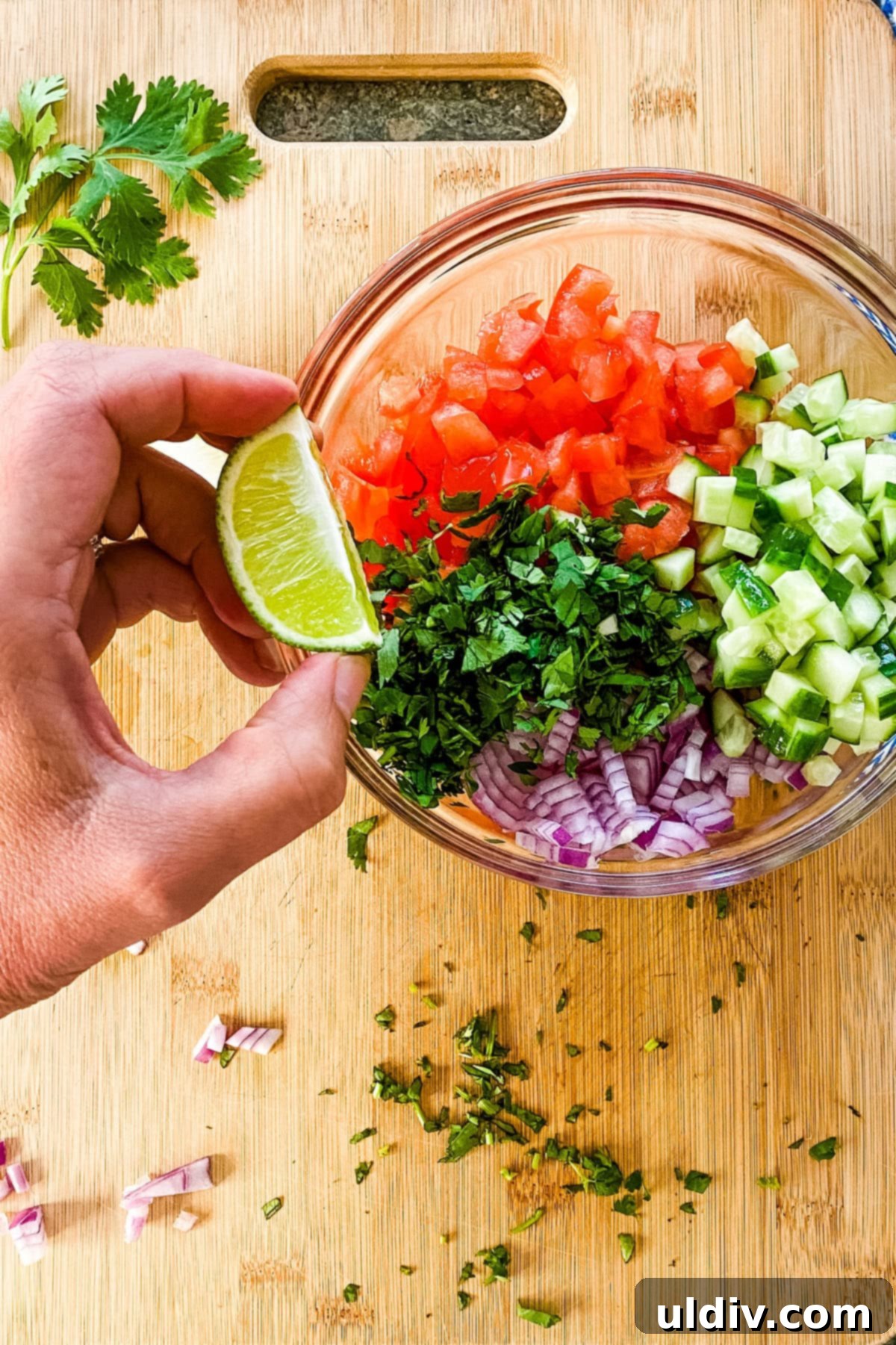 Bright & Zesty Pico 5 Fresh lime juice being squeezed over a colorful bowl of Pico de Gallo ingredients, ready for mixing.